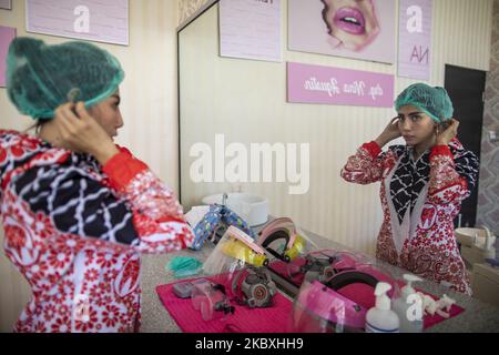 Doctor NINA AGUSTIN put on her shoe glove in Malang, West Java ...