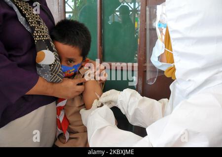 Paramedics of Puskesmas Kebayoran Lama check the temperature and vaccinate the students of elementary school, in Jakarta, Indonesia, on August 26, 2020. This activity, which was attended by hundreds of students, was part of the month of immunization for school children as well as a comprehensive health examination for public elementary school students in DKI Jakarta. (Photo by Dasril Roszandi/NurPhoto) Stock Photo