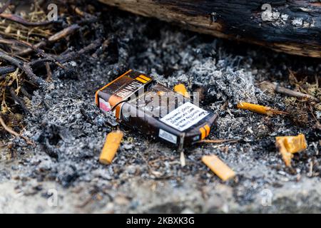 Belgrade, Serbia - November 02, 2022: Pall Mall cigarette pack and filters in a pile of ash and dirt outdoors. Save your health and stop smoking conce Stock Photo