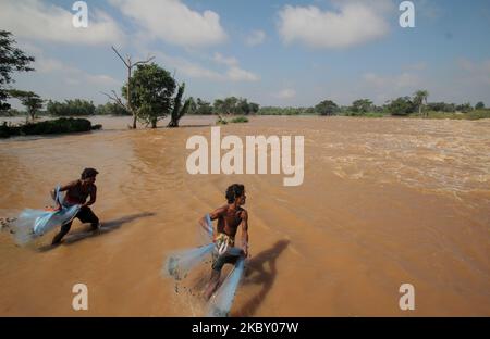 Flood affected villagers are seen near to the broken river embankments and overflowing points of the low lying area rivers those are branch rivers of Mahanadi, India, on September 1, 2020, as flood situation creates and hundreds of villages marooned after Hirakud Dam release its flood waters into the Mahanadi river after heavy downpour in the upper catchment areas due to low pressure in the Bay of Bengal Sea and it causes flood in low lying area of the coastal districts of the state and killed near by 19 people in between the couple of days (Photo by STR/NurPhoto) Stock Photo
