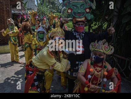 Participants in the ritual dressed as Anoman (a monkey figure in the Mahabarata story) and children dressed as animals, headed for the grave area of the creator of the Malangan Mask art (Mbah Reni) in Polowijen village, Malang, East Java, Indonesia, on August 29, 2020. The tradition of pilgrimage and sanctification with the prayer 'Mask Art Malangan' which is held once a year. This can be carried out after easing the activities of the local government during the Covid-19 outbreak towards a new normal. (Photo by Aman Rochman/NurPhoto) Stock Photo