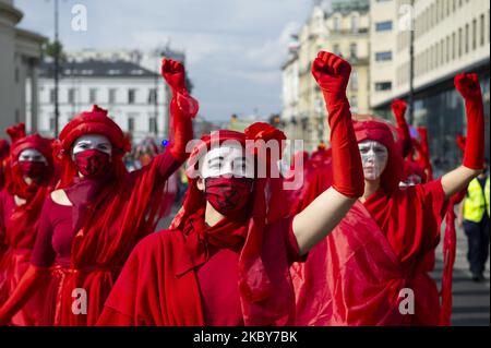 Extinction Rebellion activists dressed in red gowns as part of the Red Rebel Brigade rise their fists during a march against climate change on September 5, 2020 in Warsaw, Poland. A few thousand people took the streets in the great march for climate organised by Extinction Rebellion as the start of the climate protests season to demand immediate action from the politics and to raise awareness about climate changes. (Photo by Aleksander Kalka/NurPhoto) Stock Photo
