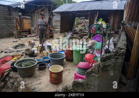 A mother is near her house which was damaged by floods in Oloboju Village, Sigi Regency, Central Sulawesi Province, Indonesia on September 9, 2020. Although it did not cause any casualties, the sudden flood due to the high intensity of rain on Tuesday (9/8/2020) evening damaged at least six houses in the village. Sigi Regency is an area located south of Palu City, the capital of Central Sulawesi province. Almost every year in the rainy season, this area is always hit by floods. (Photo by Basri Marzuki/NurPhoto) Stock Photo