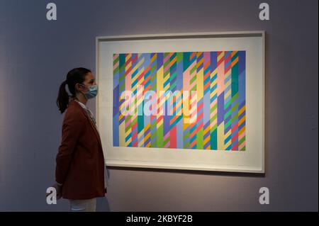 (EDITOR'S NOTE: Editorial use only) A staff member stands next to 'June', screenprint in colours, 1992-2002, by Bridget Riley (estimated sale price ?10,000-15,000) during a press preview at Christie's on September 09, 2020 in London, England. (Photo by WIktor Szymanowicz/NurPhoto) Stock Photo