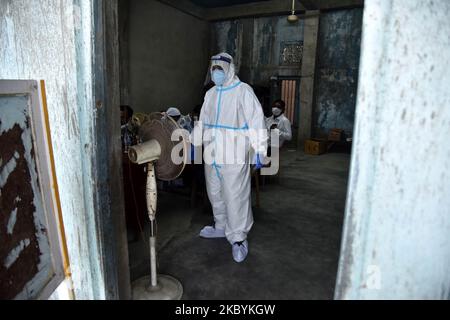 A health worker in personal protective equipment (PPE) stands in front of a fan while waiting for people to collect samples to conduct tests for the coronavirus disease (COVID-19), amid the spread of the disease in Nagaon district, in the northeastern state of Assam, India, September 12, 2020 (Photo by Anuwar Hazarika/NurPhoto) Stock Photo