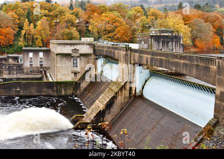 Pitlochry Perthshire Scotland the Tummel River spanned by the Dam walls trees in autumn colours on the banks Stock Photo