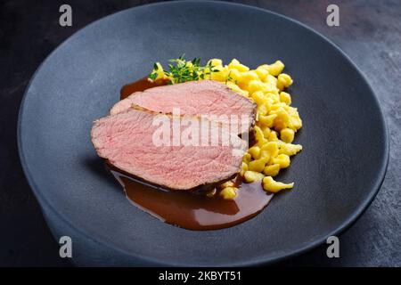 Tafelspitz roast veal slices with Swabian spaetzle served with dark beer sauce as close-up in a design plate Stock Photo