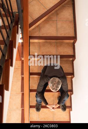 Mature man sitting on stairs Stock Photo