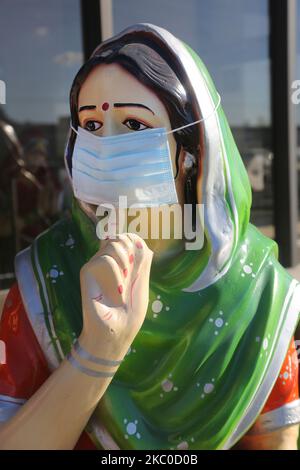 Face mask is seen on the statue of a Punjabi woman outside an Indian restaurant during the novel coronavirus (COVID-19) pandemic in Mississauga, Ontario, Canada on September 22, 2020. Cases have continued to spike in Ontario as Provincial health officials recorded 478 new cases of the virus today, up from the 425 reported one day ago. This is the third day that over 400 new cases have been recorded as new infections continue to climb in Toronto, Peel, and Ottawa. (Photo by Creative Touch Imaging Ltd./NurPhoto) Stock Photo