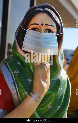 Face mask is seen on the statue of a Punjabi woman outside an Indian restaurant during the novel coronavirus (COVID-19) pandemic in Mississauga, Ontario, Canada on September 22, 2020. Cases have continued to spike in Ontario as Provincial health officials recorded 478 new cases of the virus today, up from the 425 reported one day ago. This is the third day that over 400 new cases have been recorded as new infections continue to climb in Toronto, Peel, and Ottawa. (Photo by Creative Touch Imaging Ltd./NurPhoto) Stock Photo