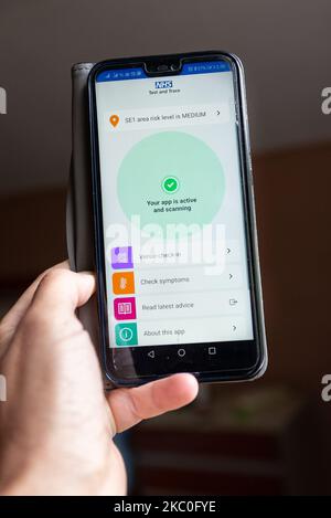 For illustrative purposes a woman holds a mobile phone with Covid-19 tracking and tracing app opened while NHS launches new application in England and Wales - London, England, September 24, 2020. Android and iPhone users of the new app already reported issues. (Photo by Dominika Zarzycka/NurPhoto) Stock Photo