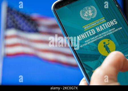 For illustrative purposes a woman holds a mobile phone with United Nations mobile app agains the USA flag as the tension between the organisation and President Donald Trump soars, on September 24, 2020 in London, UK. As UN celebrates its 75th anniversary among Covid-19 insecurity and rising international tension the USA president Donald Trump continues distancing from the organisation. (Photo Illustration by Dominika Zarzycka/NurPhoto) Stock Photo