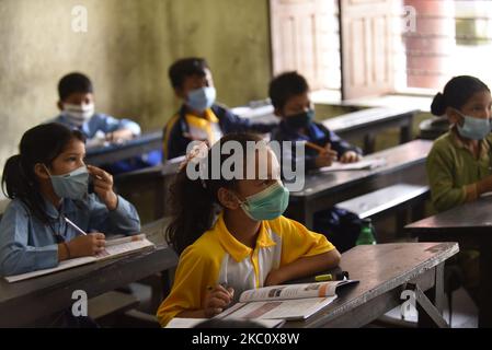 Primary School students of Prabhat Madhyamik Vidhyalaya, a government based school taking their classes after six months of complete closure due to COVID-19 pandemic fear at Thankot, Kathmandu, Nepal on September 30, 2020. Schools started resuming its classes with a proper safety measures and standard guidelines concerned towards local government's decisions. (Photo by Narayan Maharjan/NurPhoto) Stock Photo