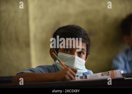 A Primary School student of Prabhat Madhyamik Vidhyalaya, a government based school taking his class along with face mask after six months of complete closure due to COVID-19 pandemic fear at Thankot, Kathmandu, Nepal on September 30, 2020. Schools started resuming its classes with a proper safety measures and standard guidelines concerned towards local government's decisions. (Photo by Narayan Maharjan/NurPhoto) Stock Photo