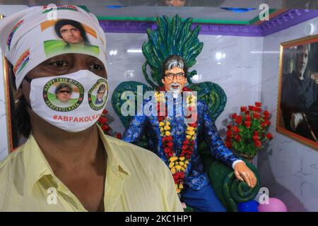 A Mamber of Indian Super star Actor Amitabh Bachchan Fans Club warring Actor Amitabh Bachchan photo printed face mask at front of Actor Amitabh Bachchan idol to celebrate his 78th birthday at Amitabh Bachchan Temple in Kolkata,India on October 11,2020.Amitabh Bachchan Fans Club members carting the cake ,pay Amitabh Bachchan idol ,Distribute Amitabh Bachchan photo printed face Mask and Free Food Distribute to poor people.India's favourite film star and Bollywood legend, Bachchan - who is known as the 'The Big B' having over 3.5 million Twitter followers is treated like royalty in the movie-mad  Stock Photo