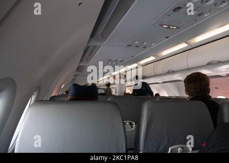 Passengers with facemasks while boarding in the cabin. Flying with Lauda Airbus A320 airplane with registration 9H-LMJ during the Covid-19 Coronavirus pandemic with passenger and crew wearing facemask. Laudamotion or Lauda is an Austrian low-cost carrier owned by Ryanair and operating by Ryanair codes FR for IATA, RYR for ICAO and RYANAIR callsign. The budget airline carrier is based in Vienna International Airport VIE LOWW or Flughafen Wien-Schwechat in Austria with a fleet of 28 Airbus Aircraft. Vienna, Austria on October 12, 2020 (Photo by Nicolas Economou/NurPhoto) Stock Photo