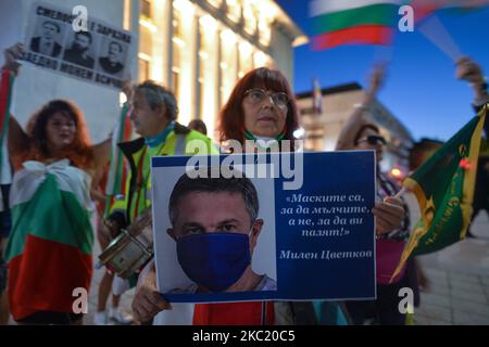 A lady holds a poster with an image of the journalist, Milen Tsvetkov, as she takes part in 100th Day of Anti-government protest outside Burgas Town Hall. Bulgarians have been demonstrating in Sofia and around the country for 100 evenings in a row, demanding the resignations of Prime Minister Boyko Borissov and Prosecutor General Ivan Geshev. On Friday, October 16, 2020, in Burgas, Bulgaria. (Photo by Artur Widak/NurPhoto) Stock Photo