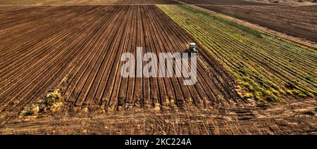 Aerial view of tractor cultivating and harrowing field at spring season ...