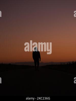 Silhouette of man walking during sunset Stock Photo - Alamy
