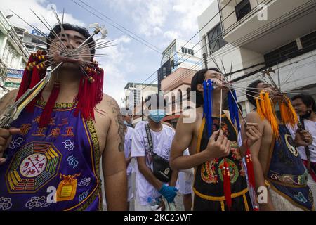 (EDITORS NOTE: Image contains graphic content.) Thai devotees are possessed by spirits and pierced with long needles during a Vegetarian ritual at the Sapam Shrine on October 19, 2020 in Phuket, Thailand. The annual Phuket vegetarian Festival will be held from October 17th to 25th. Also known as the Nine Emperor Gods Festival, devotees participating in the festival abstain from eating meat, drinking alcohol, and there to other requirements during the duration of the festival. Spirit mediums known as man song are believed to become possessed with benevolent spirits, going into a trace and takin Stock Photo
