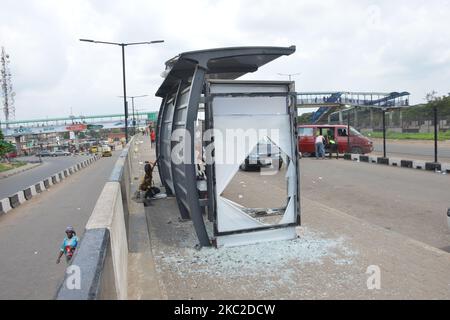 People walk past a vandalized bus stop terminal in Beger Bus stop