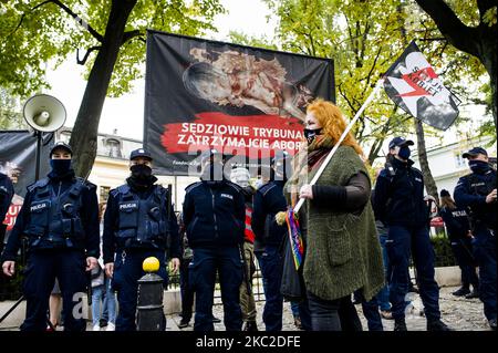 Pro-abortion activists with Women's Strike flag walking next to anti-abortion banners while The Constitutional Court was deciding to ban abortions for fetal indications, in Warsaw, Poland, on October 22, 2020. Outside of the the court activists from both sides gathered in prayers for the judges to introduce the ban or in protest against limiting women reproductive rights. (Photo by Piotr Lapinski/NurPhoto) Stock Photo