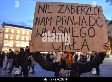 An activist seen with a placard saying 'You Want Take Away Our Right To Our Own Body'. Thousands of people marched tonight in Krakow and other Polish cities for the third day in a row of protests against the near-total ban on abortion. The protest is a direct reaction to Thursday’s ruling by Poland’s Supreme Court that existing law authorizing termination of pregnancy for fetal is against the constitution, effectively tightening one of the strictest abortion regimes in Europe. On Saturday, October 24, 2020, in Krakow, Poland. (Photo by Artur Widak/NurPhoto) Stock Photo