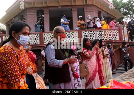 Masked devotees watch final rituals for Goddess Durga before the