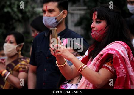 Masked devotees watch final rituals for Goddess Durga before the