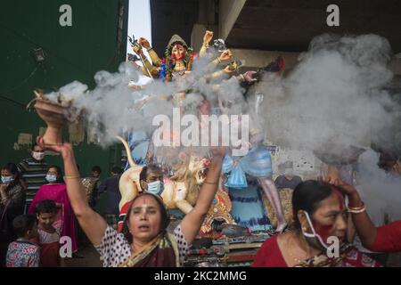 Hindu devotees dance during a procession, part of the immersion rituals in front of an idol of the Hindu goddess Durga in the Bank of Buriganga river during the final day of Durga Puja festival in Dhaka on October 26, 2020. (Photo by Ahmed Salahuddin/NurPhoto) Stock Photo