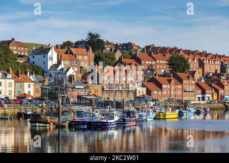 Pleasure and Fishing Boats on the River Esk with reflections Whitby North Yorkshire England Stock Photo