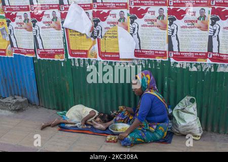 A homeless Bangladeshi mother having her launch on the footpath while her daughter is sleeping beside on October 30, 2020 in Dhaka, Bangladesh. (Photo by Khandaker Azizur Rahman Sumon/NurPhoto) Stock Photo