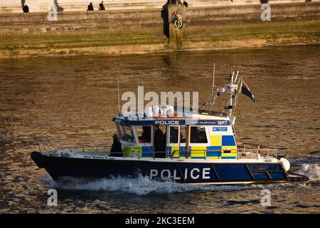 A Metropolitan Police boat motors along the River Thames, seen from Westminster Bridge in London, England, on November 6, 2020. England yesterday began its second national coronavirus lockdown, announced by British Prime Minister Boris Johnson last Saturday, citing fears that covid-19 again threatened to overwhelm the National Health Service (NHS). Pubs, bars, restaurants and non-essential shops are all required to be closed until the currently scheduled end date of December 2. People have meanwhile been asked to stay home as much as possible, although schools and other educational institution Stock Photo