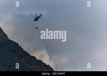 A helicopter of the Government Flying Service of Hong Kong drops water on the flanks of Kowloon Peak, on November 8, 2020. The mountain is the location of the reputed ''Suicide Cliff'' viewpoint. (Photo by Marc Fernandes/NurPhoto) Stock Photo