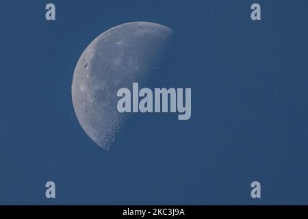 The Moon as seen from the Netherlands in the blue sky. The Moon or Luna phase is at a Third Quarter with the left side illuminated about 51% as seen from the northern hemisphere of the earth. The Moon is Earth's natural satellite in orbit and the closest celestial object in the universe. Eindhoven, Netherlands on November 8, 2020 (Photo by Nicolas Economou/NurPhoto) Stock Photo