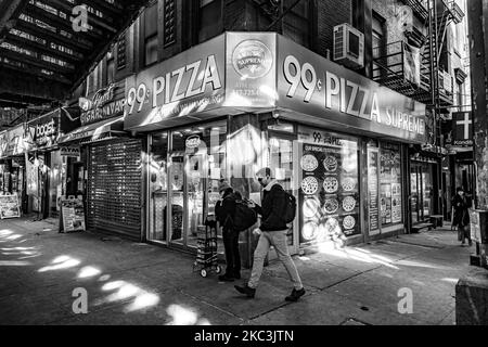 (EDITOR'S NOTE: Image was converted to black and white) A man walking. Daily life view of the road and street under the subway railroad air-bridge metal construction of M, J and Z lines near Marcy Ave station, with restaurants, shops, the famous dollar slice pizza, traffic with cars and trucks and with sidewalks in Broadway street in Brooklyn, New York City. Brooklyn is the most populous county in the state of New York and the second-most densely populated in the United States. Brooklyn, NY, USA on 13 February 2020. (Photo by Nicolas Economou/NurPhoto) Stock Photo