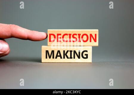 Decision making symbol. Concept words Decision making on wooden blocks. Beautiful grey table grey background. Businessman hand. Business and decision Stock Photo