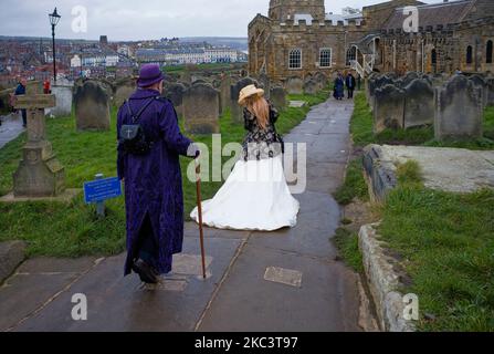 Goth couples walk near the church at Whitby during goth weekend Stock Photo