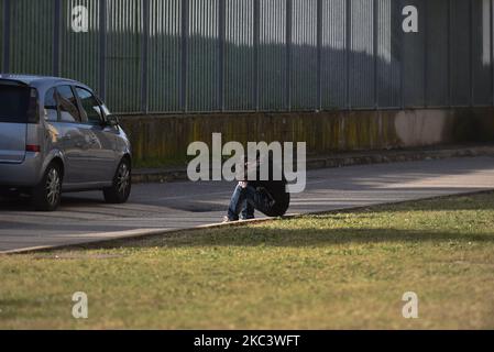 a person of Asian origin sitting at the edge of the road that runs along the buffer area set up below the Euganean stadium waits to collect the result of the tampon. Padua, November 11, 2020, italy With the increase in the curve of infections and consequently of the infected, the hospitals of the Veneto and specifically of Padua and Schiavonia are close to collapse. To ease the grueling workload on the shoulders of doctors and nurses, the army took to the field with its qualified personnel. Army doctors and nurses from today preside and help state doctors and nurses at the Euganean Stadium in  Stock Photo