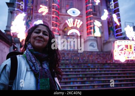 British artist Chila Kumari Singh Burman poses with her neon light installation 'Remembering A Brave New World', which covers the facade of the Tate Britain art gallery in London, England, on November 13, 2020. The work, noted to combine 'Hindu mythology, Bollywood imagery, colonial history and personal memories' (including Burman's family's ice-cream van), forms the fourth annual Winter Commission at the gallery and was unveiled today, on the eve of Diwali, the Indian festival of lights. The installation will be in place until January 31 next year. (Photo by David Cliff/NurPhoto) Stock Photo
