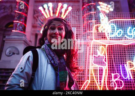 British artist Chila Kumari Singh Burman poses with her neon light installation 'Remembering A Brave New World', which covers the facade of the Tate Britain art gallery in London, England, on November 13, 2020. The work, noted to combine 'Hindu mythology, Bollywood imagery, colonial history and personal memories' (including Burman's family's ice-cream van), forms the fourth annual Winter Commission at the gallery and was unveiled today, on the eve of Diwali, the Indian festival of lights. The installation will be in place until January 31 next year. (Photo by David Cliff/NurPhoto) Stock Photo