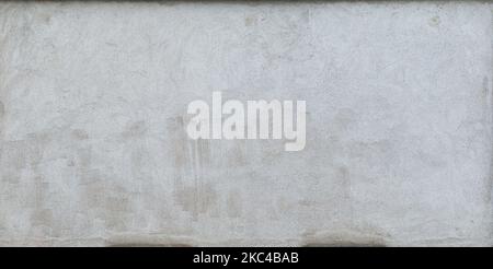 Front view of a plastered gray stone wall with stains from graffiti removal. Abstract high resolution full frame textured background. Stock Photo