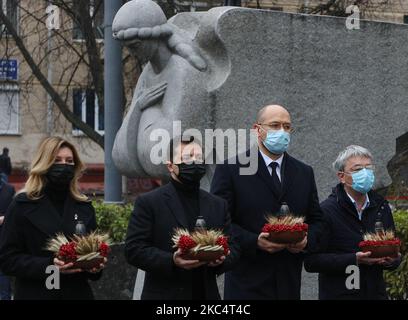 President of Ukraine People Volodymyr Zelenskiy (2nd L), first Lady Olena Zelenska (L) and Prime Minister of Ukraine Denys Shmyhal (2nd R) lit candles and lay bouquets from ears ang arrowwood to the memorial of Great Famine victims during mourning rally in Kyiv, Ukraine, November 28, 2020. Ukraine honors the memory of the victims of the famines and Great Famine (Holodomor) of 1932 – 1933 when 4.5 million Ukrainians, including 600,000 unborn children, were starved to death by the Soviet regime under Joseph Stalin. (Photo by Sergii Kharchenko/NurPhoto) Stock Photo