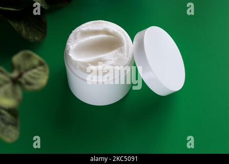 mock up of white jar of cream on a green background, with copy space  Stock Photo