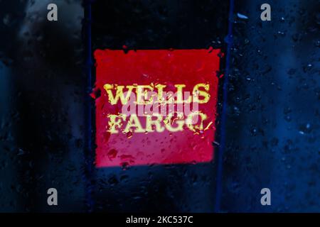 Wells Fargo logo displayed on a phone screen is seen through raindrops on the window in this illustration photo taken in Poland on November 30, 2020. (Photo by Jakub Porzycki/NurPhoto) Stock Photo