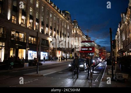 Cyclists line up ahead of traffic on Regent Street during twilight as the evening light drops, London, England, UK Stock Photo