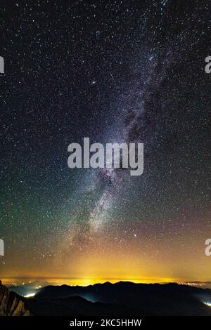 Milky Way captured with long exposure photography technique. Milkyway is the visible part of our galaxy that contains our Solar System as seen during the night from Olympus Mountain the mythical mountain in Ancient Greek culture, between Petrostrouga refuge and Skourta peak at the hiking trail above 2000m above the sea level in Greece during the night. Night landscape with trees, forest, summits with colorful Milky Way sky dome, cloudless sky at mountains with the starry sky with hills at summer with the beautiful Universe and Space background. Olympus Mountain National Park, Greece - October  Stock Photo