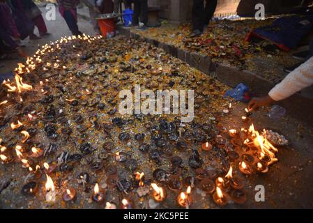 A Nepalese devotee offering butter lamps on the occasion of Bala Chaturdashi festival celebrated in the premises of Pashupatinath Temple, Kathmandu, Nepal on Sunday, December 13, 2020. It is believe that dropped seeds in remembrance of beloved ones on the occasion of Bala Chaturdashi rituals, can secure a better place in heaven for their beloved ones and their deceased relatives. (Photo by Narayan Maharjan/NurPhoto) Stock Photo