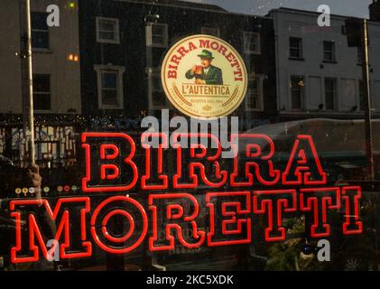 An advertising for Birra Moretti, an Italian brewing company, seen in the window of Camden Bites & Brews cocktail bar in Dublin. On Monday, December 14, 2020, in Dublin, Ireland. (Photo by Artur Widak/NurPhoto) Stock Photo