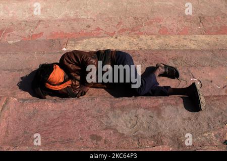 A man uses a cloth to cover his face while sleeping outside a mosque on a winter morning, at Jama Masjid, on December 19, 2020 in Delhi. India crossed one crore Covid-19 cases, adding 10 lakh infections in nearly a month, even as the virus spread slowed and recoveries surged to over 95.50 lakh, according to Union health ministry. (Photo by Mayank Makhija/NurPhoto) Stock Photo